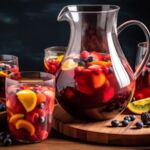 Eine Karaffe Sangria mit frischen Früchten, umgeben von Gläsern gefüllt mit Orangen, Beeren und Zitronen, auf einem Holztisch.