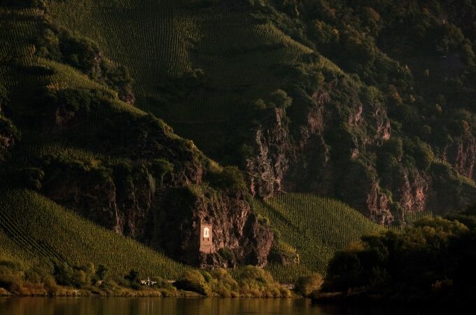 Weinberg Erdener Treppchen von Schmitges, steile grüne Hänge mit Reben, Felsen und Flussufer, perfekte Bedingungen für feinste Rieslinge.