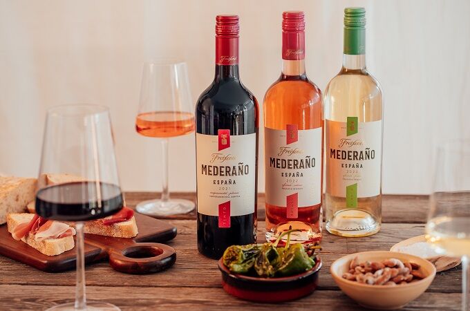 Freixenet Mederano Weine auf einem Tisch mit spanischen Tapas, Olivenöl und weiterer Dekoration.