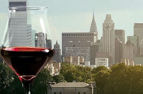 Ein Glas roter Wein aus den USA vor der Skyline von New York City. Genießen Sie amerikanischen Rotwein in urbaner Eleganz.