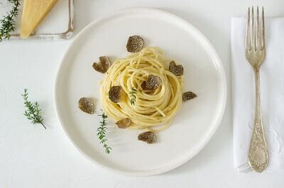 Ein eleganter Teller mit Spaghetti und Trüffeln, perfekt ergänzt durch einen edlen Wein. Ideal für Feinschmecker-Momente zu Hause!