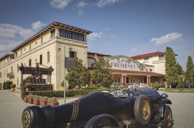 Historisches Freixenet-Gebäude in Spanien mit Oldtimer im Vordergrund und blauem Himmel im Hintergrund – Entdecken Sie die Welt des Premium-Cava!