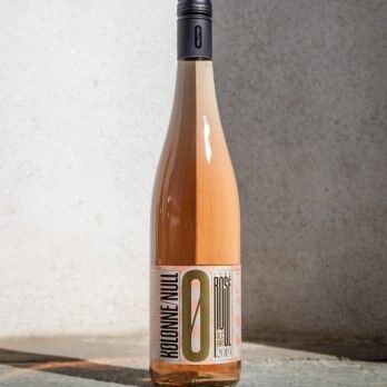 Flasche Kolonne Null Rosé Wein, alkoholfreier Rosé, in elegantem Design mit schwarzem Schraubverschluss auf grauem Hintergrund. Genuss ohne Reue!