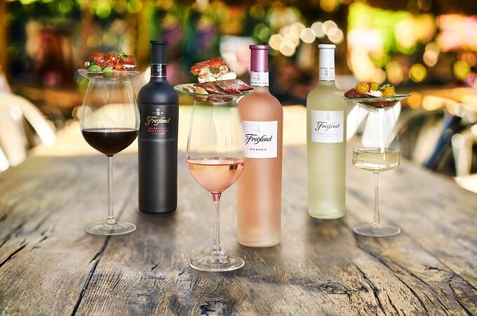 Drei Freixenet Weine (Cabernet Sauvignon, Rosado, Sauvignon Blanc) in Flaschen und passenden Weingläsern mit Vorspeisen auf einem Tisch. Perfekt für besondere Anlässe!