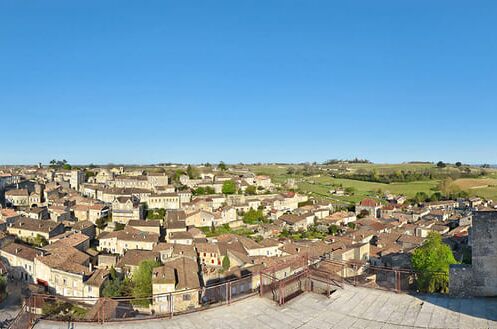 Panoramablick auf Saint-Emilion, ein malerisches Dorf in Bordeaux, bekannt für seine hochwertigen Weine, mit Kirche und Weinbergen im Hintergrund. Exklusiver Weingenuss!