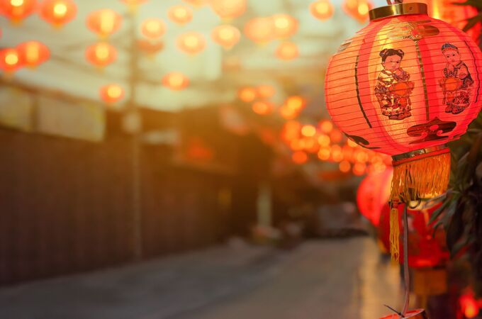 Eine stimmungsvolle Straßenszene in China mit traditionellen roten Laternen, die im warmen Licht erstrahlen.