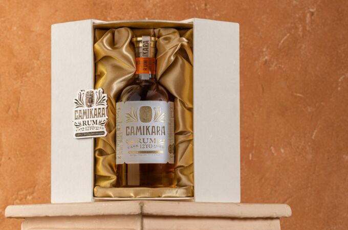 Flasche des Camikara 12 Jahre gereiften Rums, stilvoll verpackt in einer weißen Geschenkbox mit goldenem Stoff.