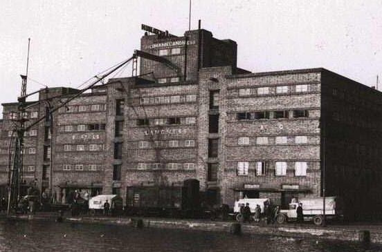 Ein altes Foto einer Lagerhalle am Hamburger Hafen, in der Weine gelagert wurden. Entdecken Sie die Geschichte des Weinhandels in Hamburg.