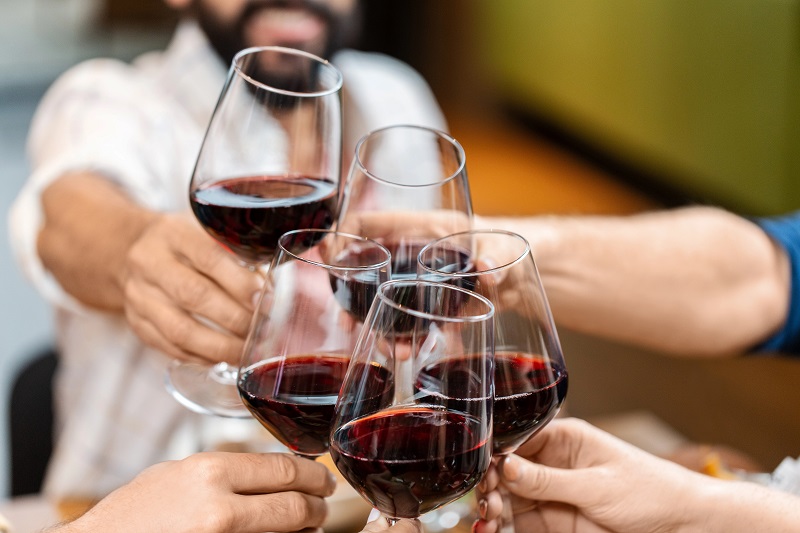 Sangiovese Wein Mehrere Hände stoßen mit Gläsern hochwertigen Sangiovese-Weins an, ein Symbol für geselligen Weingenuss und italienische Lebensfreude.